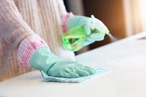 Happy woman cleaning kitchen countertop photo