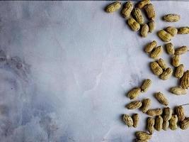 Open peanuts shot macro in studio, white wall texture background photo