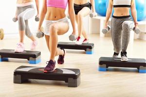 Group of smiling people lifting barbells photo