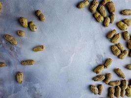 Open peanuts shot macro in studio, white wall texture background photo