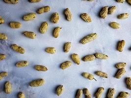 Open peanuts shot macro in studio, white wall texture background photo