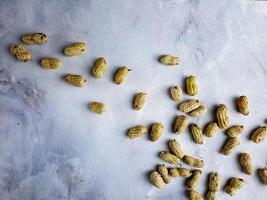 Open peanuts shot macro in studio, white wall texture background photo