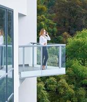 Businesswoman wearing mask standing on balcony photo