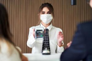 Receptionist wearing a mask working in a hotel photo