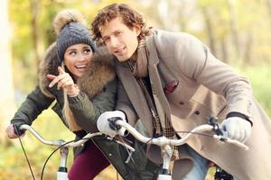 Happy couple on bikes in forest during fall time photo