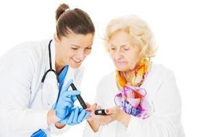 Doctor Examining Senior Woman's Blood Sugar photo