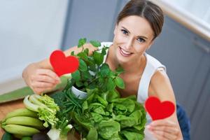 Healthy adult woman with green food in the kitchen photo