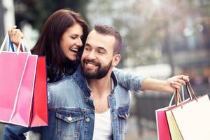 Portrait of happy couple with shopping bags after shopping in city photo