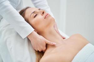 Young nice woman having face massage in spa photo