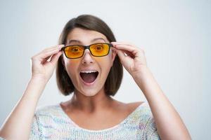 Attractive woman wearing yellow blue blocking glasses isolated over white background photo