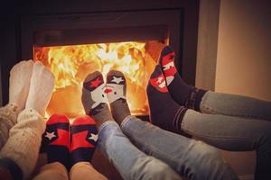 Legs of group of friends relaxing over the firepllace photo