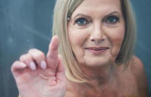 Senior woman taking shower at home photo