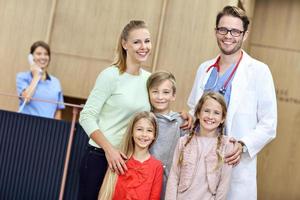 Mother and children together in hospital with doctor photo