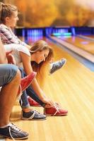 Friends putting on bowling shoes photo