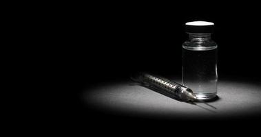 frasco de vacina e seringa em fundo escuro, luz focal video