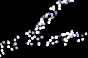 Abstract bokeh of white city lights on black background. defocused and blurred many round light photo