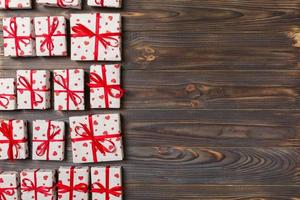 valentine or other holidays concept. Lots of Gift boxes on wood background top view. Presents in craft paper decorated with red ribbon bows and heart. top view with copy space for text frame photo