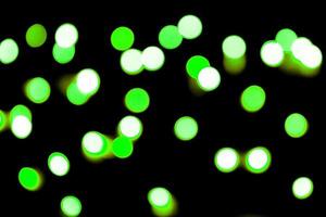 Unfocused abstract colourful bokeh black background. defocused and blurred many round green light photo