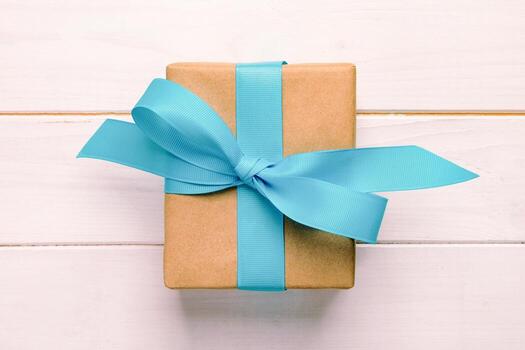 caja de regalo con lazo azul sobre mesa de madera blanca con espacio para copiar. vintage, vista superior tonificada foto
