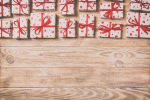 valentine or other holidays concept. Lots of Gift boxes on wood background top view. Presents in craft paper decorated with red ribbon bows and heart. top view with copy space for text frame photo