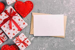 Envelope Mail with Red Heart and gift box over grey cement Background. Valentine Day Card, Love or Wedding Greeting Concept photo