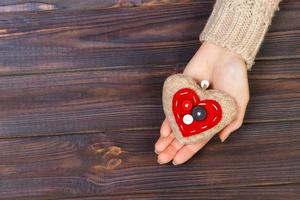 with heart in hands on wooden background. Valentine's Day concept with copyspace photo