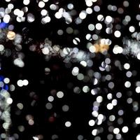 Abstract bokeh of white city lights on black background. defocused and blurred many round light photo