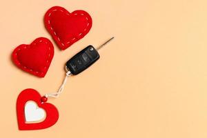 Top view of car key, wooden and textile hearts on colorful background. Saint Valentine's Day concept with copy space photo
