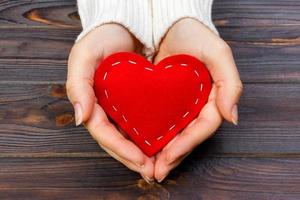 A woman holds a red heart in her hands. Love concept photo