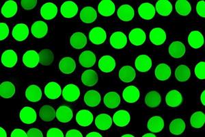 Unfocused abstract green bokeh on black background. defocused and blurred many round light photo