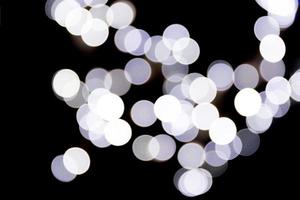 Unfocused abstract white bokeh on black background. defocused and blurred many round light photo