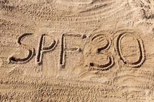 Sun protect factor thirty concept. SPF 30 word written on the beach photo