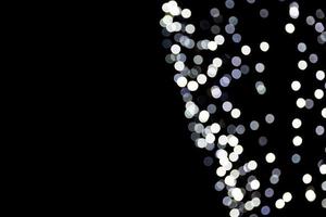 Abstract bokeh of white city lights on black background. defocused and blurred many round light photo