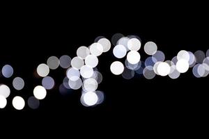 Abstract bokeh of white city lights on black background. defocused and blurred many round light photo