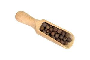 allspice in a wooden bowl. Black pepper. isolated on white background. photo