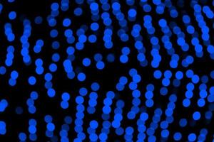 Unfocused abstract dark blue bokeh on black background. defocused and blurred many round light photo