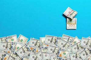 Heap of hundred Dollar Bills on colored background top view, with empty place for your text business money concept photo