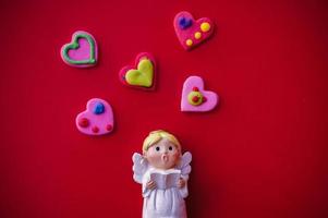 Cupid doll and heart-shaped on red background photo