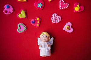 Cupid doll and heart-shaped on red background photo