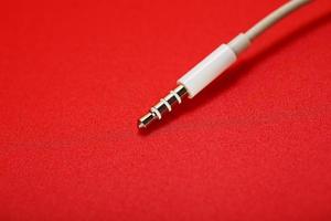 White connector AUX white cable on a red background photo