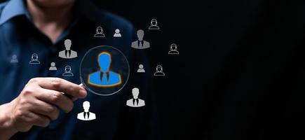 Headhunting, Recruitment and HRM all picking workers. Magnifier glass focus to manager icon which is among staff icons for human development recruitment leadership and customer target group concept. photo