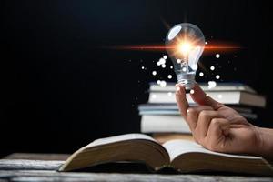 Light bulbs and books. Concept of reading books, knowledge, and searching for new ideas. Innovation and inspiration, Creativity with twinkling lights, the inspiration of ideas. photo