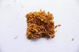 bawang goreng or Pile of fried Indonesian Deep Onion fries or shallots with circle shape isolated on white background. photo