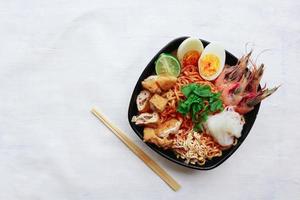 laksa, laksa curry made from vermicelli, noodles, bean sprouts, egg, tofu lime, and shrimp with a spicy soup sauce that is rich in spices. laksa served on bowl, isolated on white background. photo