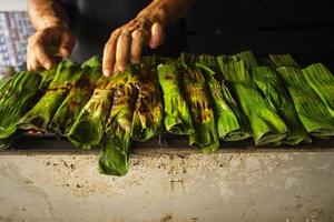 otak - otak is a food made from minced mackerel fish meat wrapped in banana leaves, baked, and served with spicy and sour sauce. otak-otak is traditional fish cake from indonesia photo