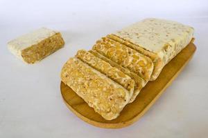 Raw tempeh or tempe. tempeh slices in white background. raw soybean seeds. Tempe is a traditional Indonesian food made from fermented soybeans. photo