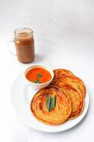 roti canai and teh tarik. paratha bread or canai bread or roti maryam, favorite breakfast dish. served on plate photo