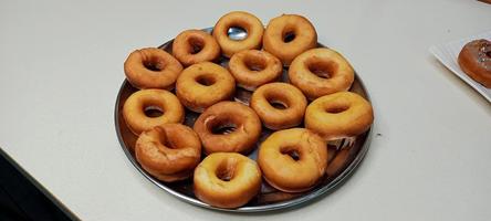 assorted donuts with chocolate frosted, pink glazed and sprinkles donuts. Donuts in hand or tray photo