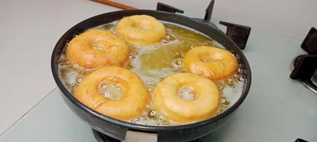 assorted donuts with chocolate frosted, pink glazed and sprinkles donuts. Donuts in hand or tray photo