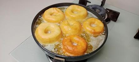 rosquillas variadas con glaseado de chocolate, glaseado rosa y rosquillas. donas en mano o bandeja foto